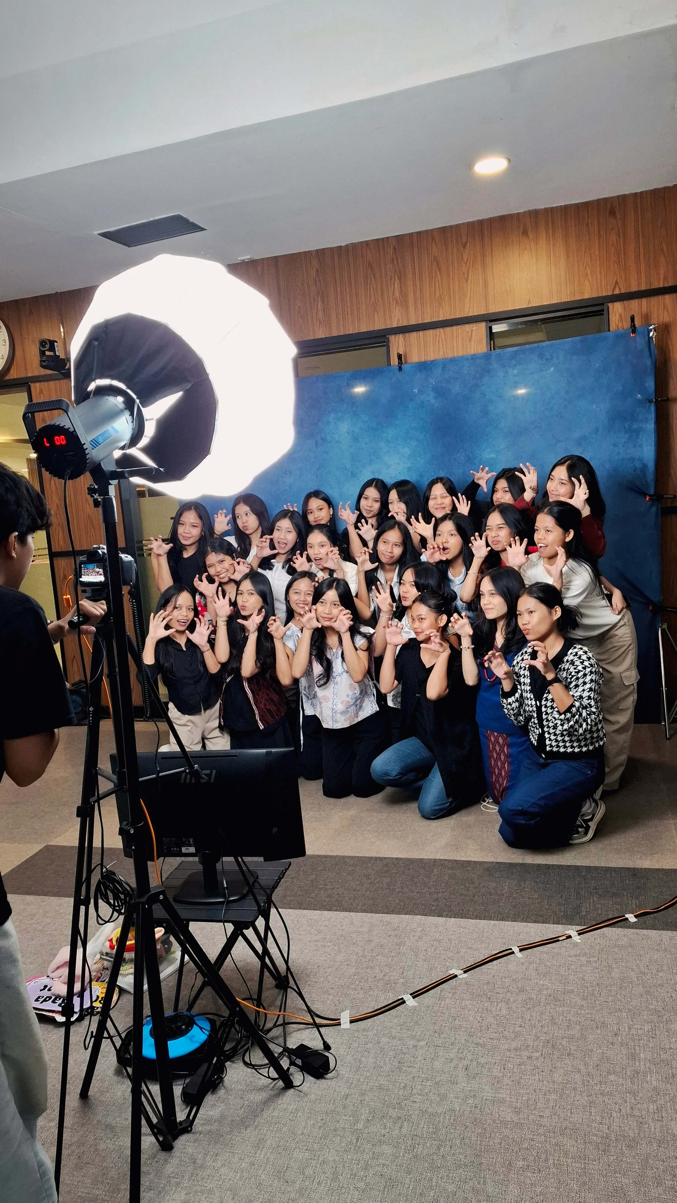 Setup photobooth DigiSnap di lokasi — lighting studio, kamera, dan backdrop, dengan tamu yang sedang berpose